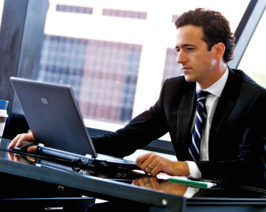 Man sitting at desk working on laptop.