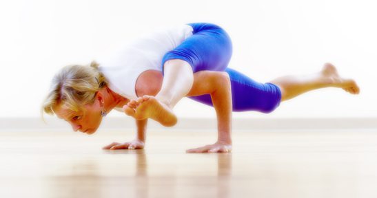 woman performing yoga pose on wood floor