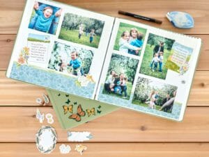 Endless Meadows Scrapbook Bundle with scrapbook filled with photos open on wood desk.