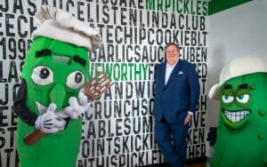 "Mr. Pickle" mascott holding fork stands next to Mike Nelson, chief executive officer of Mr. Pickle's Sandwich Shop.