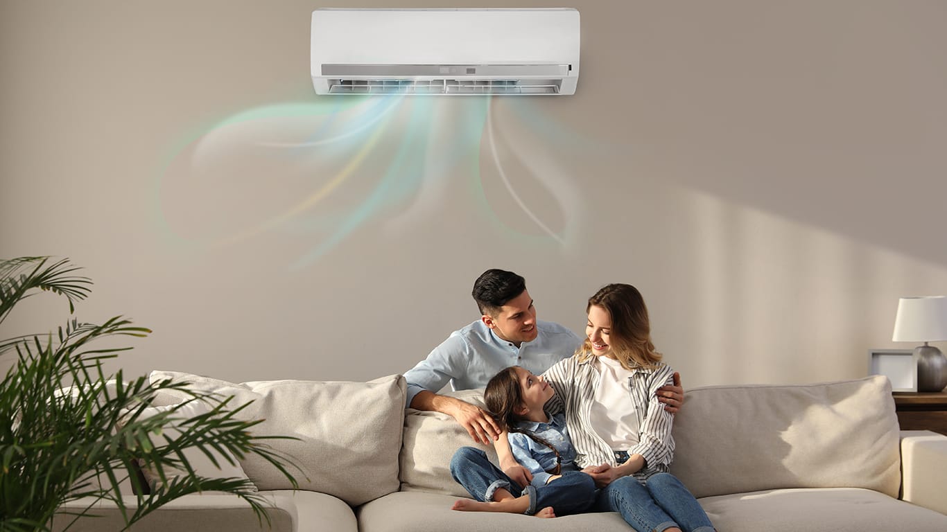 Happy family resting under air conditioner on beige wall at home.