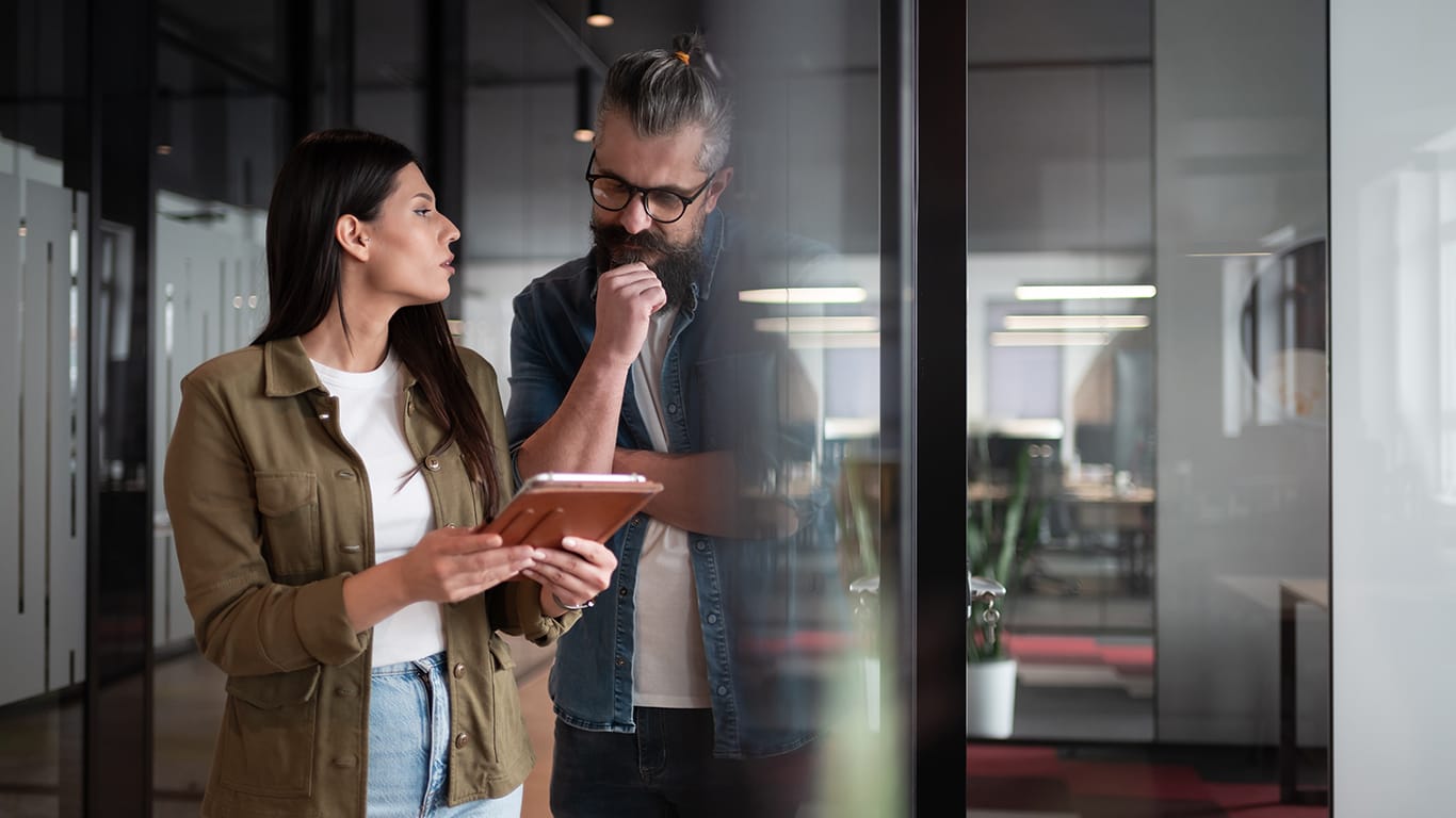 Creative millennials, casual business team, small business owners, working on social media strategy and brand development with a digital tablet in a modern, open space startup office.