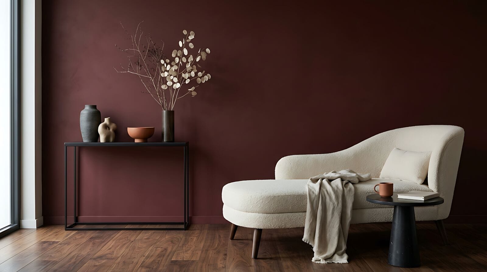 Dark burgundy living room interior with modern chaise lounge and floral arrangement.