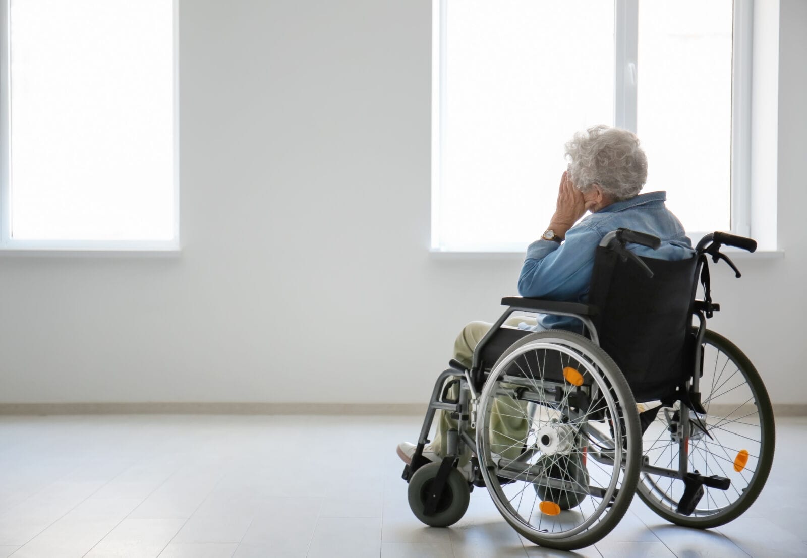 Lonely senior woman in wheelchair indoors.